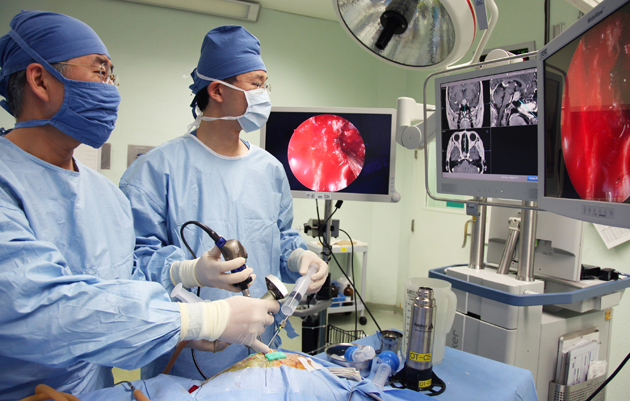 신경외과 백선하 교수와 이비인후과 원태빈 교수가 두개저 내시경 수술을 하고 있다.  