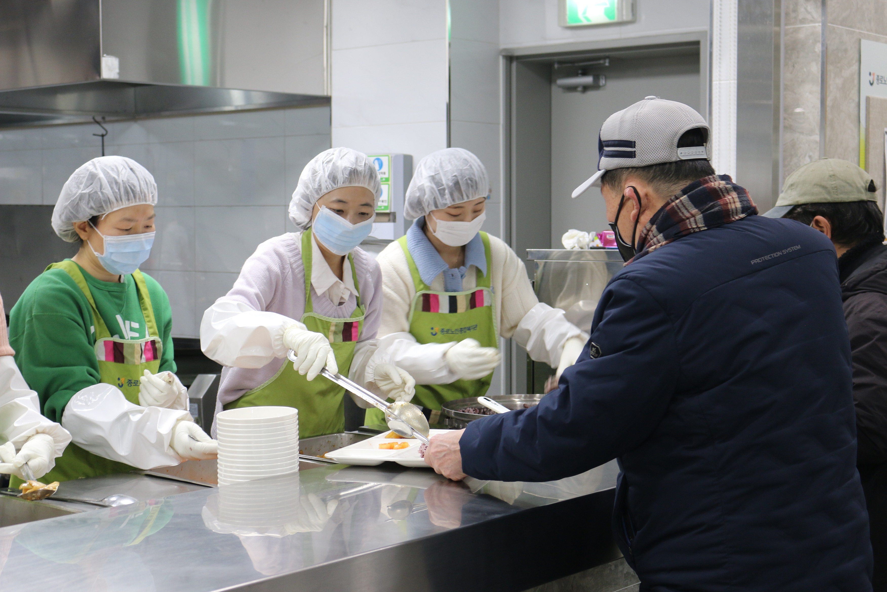 서울대병원 임직원들이 종로노인종합복지관에서 배식 봉사를 진행하고 있다.